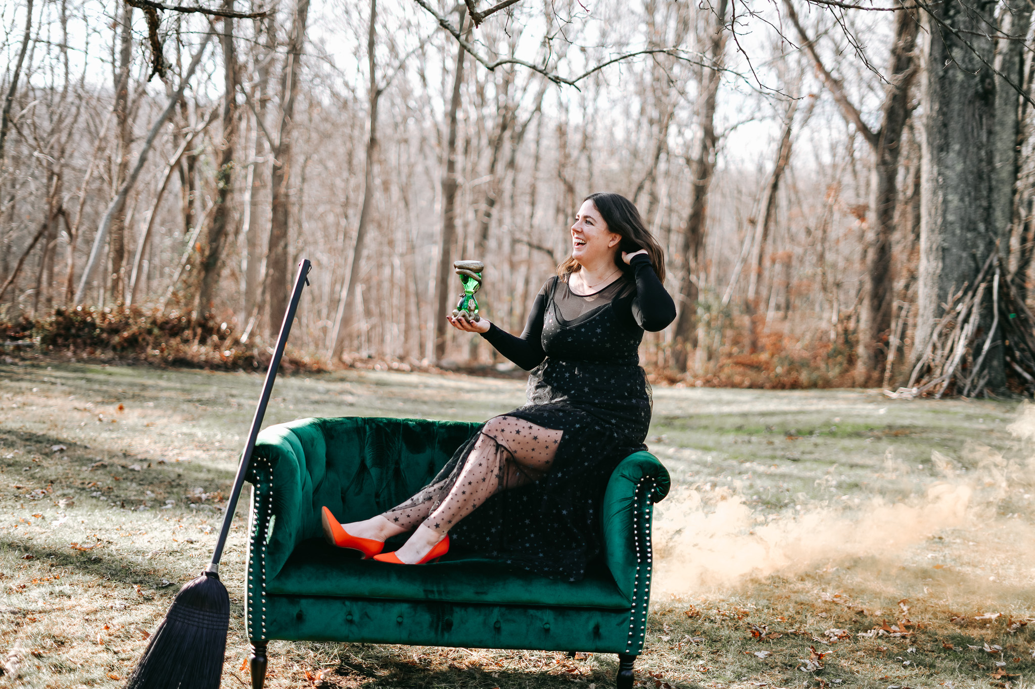 Sara Walka sitting outdoors in the woods on a green velvet sofa